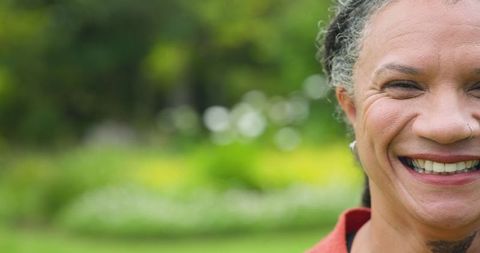 Mature woman smiling in relaxed garden atmosphere with copy space