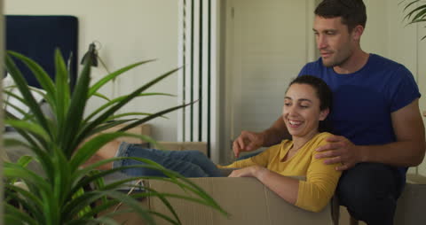 Happy Couple Enjoys New Home Amidst Moving Boxes