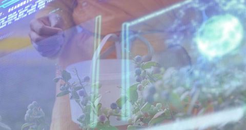 Pointing at holographic interface over potted berry plant in high-tech lab