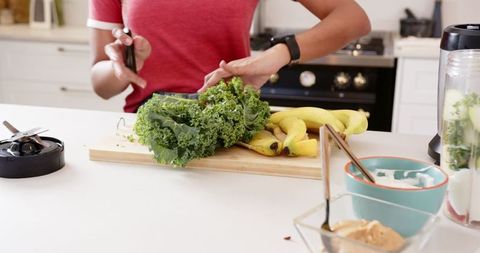 Preparing Healthy Green Smoothie Ingredients in Modern Kitchen