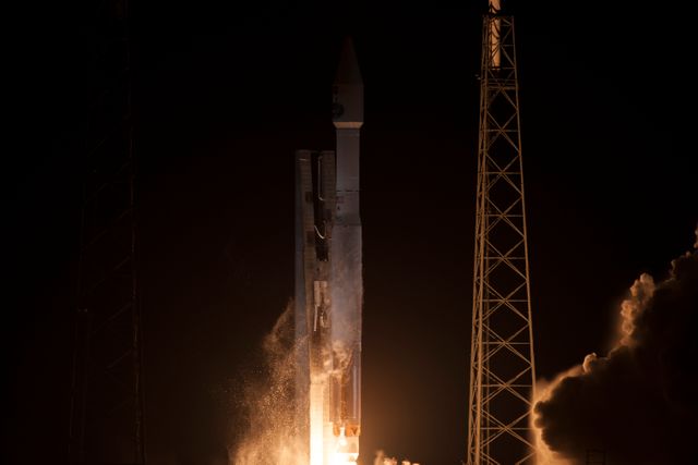 Atlas V rocket igniting during night launch at Cape Canaveral, carrying NASA's TDRS-L satellite into orbit. Ideal for use in aerospace promotions, space exploration articles, and educational materials on satellite technology and telecommunications.