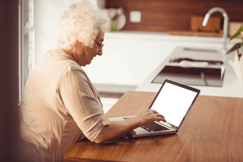 Elderly woman typing on laptop at home in transparent background