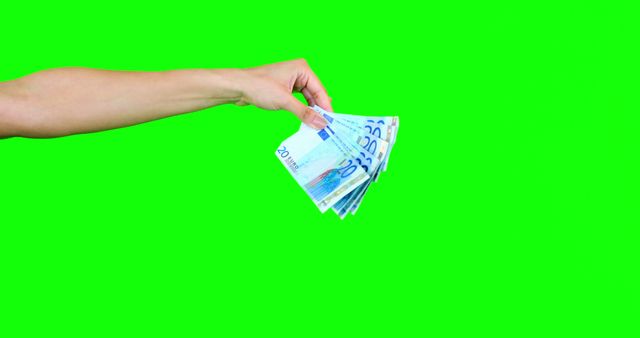 A Caucasian hand is holding a fan of Euro banknotes against a bright green background, with copy space. The image suggests a concept of financial transactions, savings, or cash incentives.