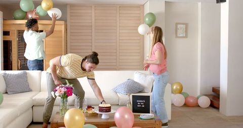 Friends celebrating new job with cake and balloons