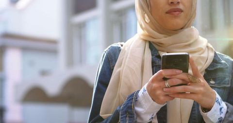 Woman in Hijab Using Smartphone in Urban Setting