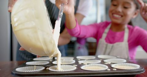 Excited Daughter and Mother Baking Cupcakes Together in Kitchen