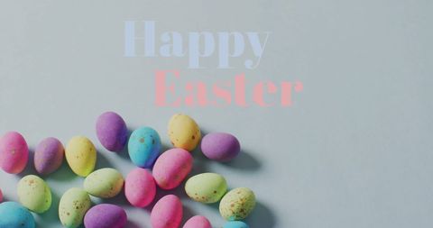 Vibrant easter eggs with happy easter greeting on grey background