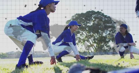 Young female softball players stretching on field in team uniforms