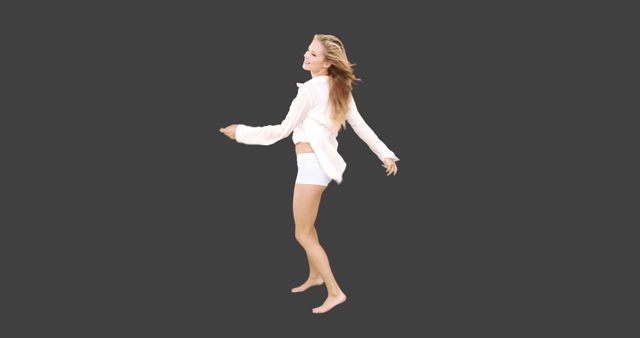 Joyful Woman Twirling in Casual White Clothes against Dark Background - Download Free Stock Images Pikwizard.com