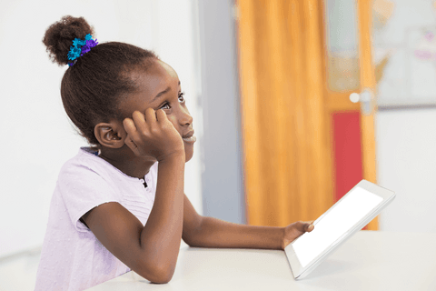 thoughtful young girl holding transparent digital tablet by classroom desk - Download Free Stock Videos Pikwizard.com
