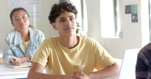 Focused teenage boy listening in high school classroom