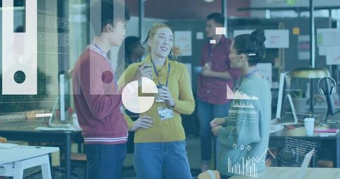 Young professionals chatting in open office with data dashboards, coffee and collaboration