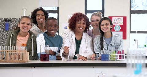 Teacher guiding diverse students in science laboratory experiment