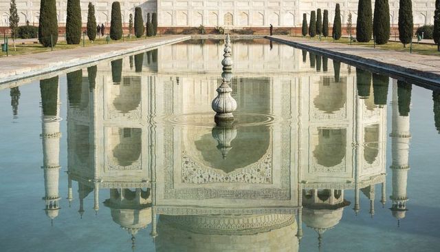 Taj mahal reflection in central pool with symmetrical charbagh and cypress trees