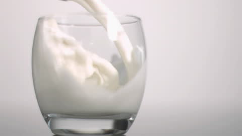 Fresh Milk Pouring into Glass in Slow Motion