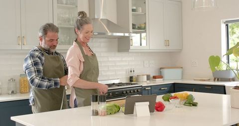 Senior Couple in Kitchen Collaboratively Preparing Meal