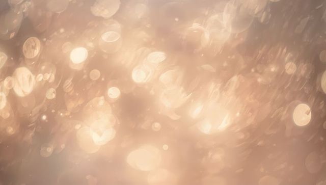Shimmering golden bokeh glow with soft lens flares and warm peach tones