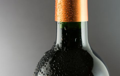 Close-up of Wet Wine Bottle Against Gray Background