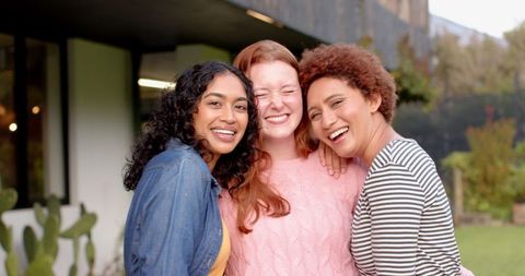 Diverse Female Friends Hugging Outdoors at Modern Home