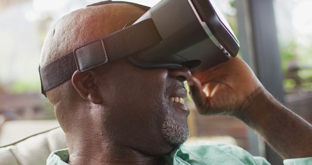 Man engaging with virtual reality technology, experiencing immersive and innovative entertainment at home. This image is ideal for advertisements related to VR products, digital technology promotions, or articles on modern entertainment and interactive experiences.