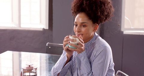 Businesswoman Relaxing with Coffee at Desk in Office