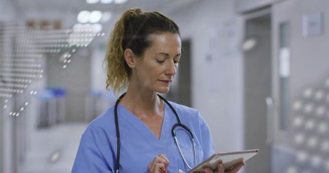Nurse Using Tablet in Hospital Hallway with Stethoscope and Digital Interface Overlays