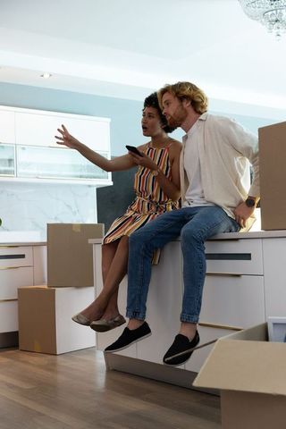 Diverse Couple Planning New Home with Moving Boxes