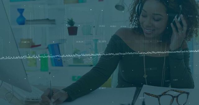 Professional Woman Writing at Desk with Headset in Modern Office