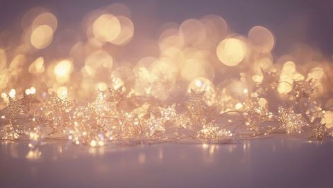 Warm golden star lights twinkling on reflective surface with soft dreamy bokeh and sparkle