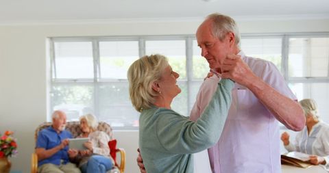 Happy Senior Couple Dancing in Nursing Home Living Room