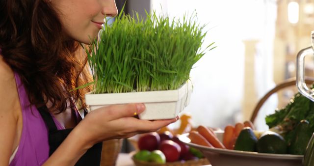 Female staff smelling fresh green grass in organic market