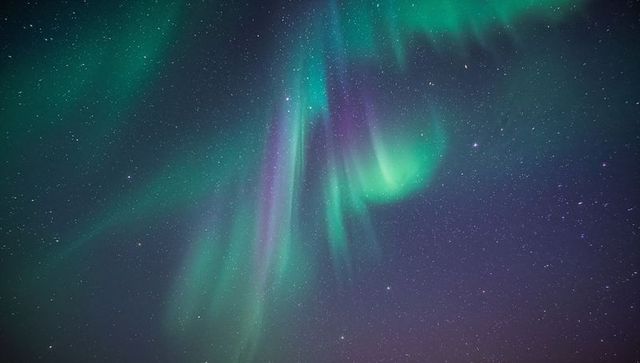 Epic Aurora Borealis Curtains of Green and Purple Dancing Over Starry Polar Night Sky