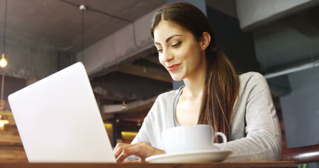 Young Woman Working on Laptop in Cozy Café with Coffee - Download Free Stock Images Pikwizard.com