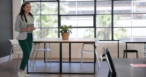 Young Woman Using Digital Tablet in Elegant Modern Office