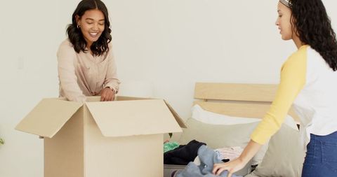Smiling women unpacking and organizing at home