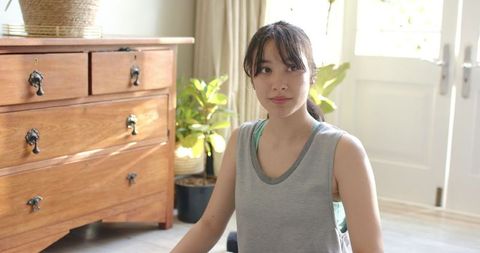 Asian Woman Practicing Yoga in Cozy Living Room Setting