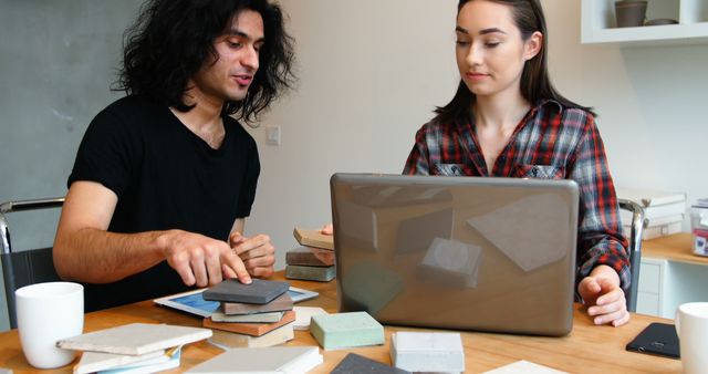 Two Designers Discussing Color Swatches and Laptop at Wooden Desk - Download Free Stock Images Pikwizard.com