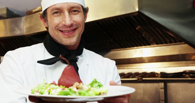 Smiling Chef Showcasing Gourmet Dish in Restaurant Kitchen - Download Free Stock Images Pikwizard.com