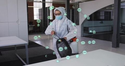 Female technician disinfecting open-plan office wearing ppe with augmented reality overlay