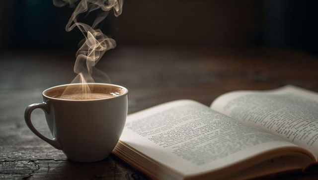 Steaming Coffee Cup on Rustic Wooden Table with Open Book for Cozy Reading Moment
