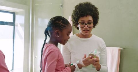 African American Mother and Daughter Toothbrushing Routine at Home