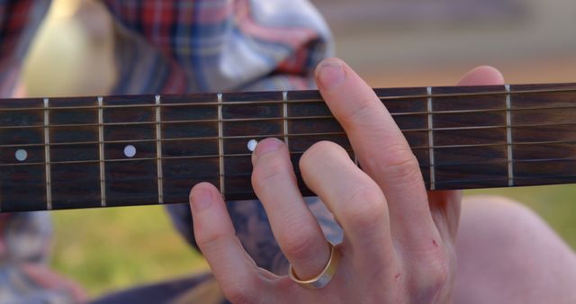 Hand of caucasian man playing acoustic guitar in garden - Download Free Stock Photos Pikwizard.com