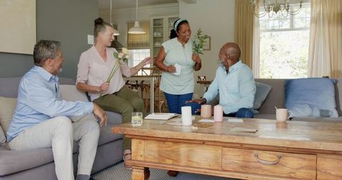 Friendly Seniors Sharing Flowers and Conversation in Cozy Living Room