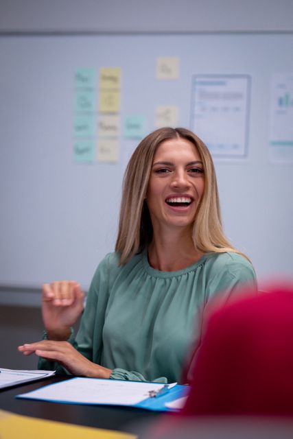 Happy caucasian businesswoman laughing with colleagues during an office meeting. working in business at a modern office.