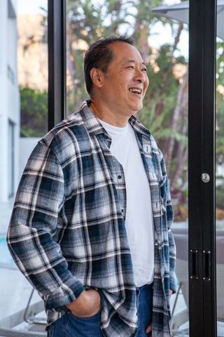Mature man enjoying quiet moment by glass doors in modern home