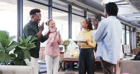 Colleagues Celebrate Birthday with Cake at Bright Modern Office