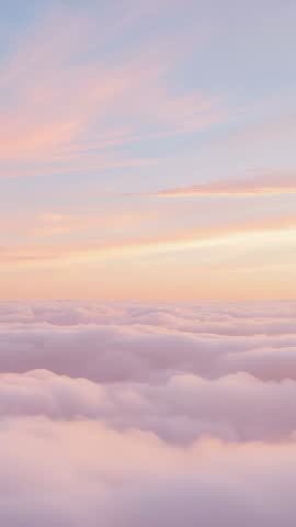 Vertical drone video showing sunrise over pastel cloud sea creating serene ambient light