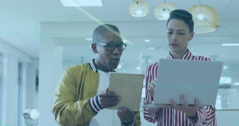 Professionals Collaborating with Laptop and Tablet in Modern Office