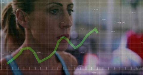 Fit woman tracking workout progress with green analytics graph overlay in modern gym