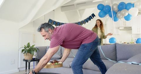 Mature couple crafting joyful birthday celebration at home